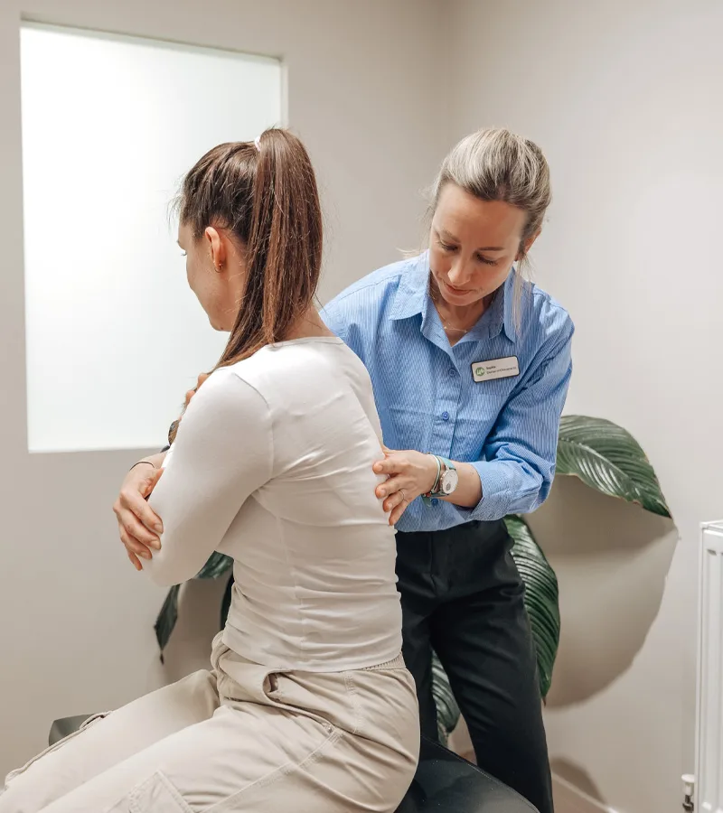 Chiropractor checking a pregnant patient’s posture