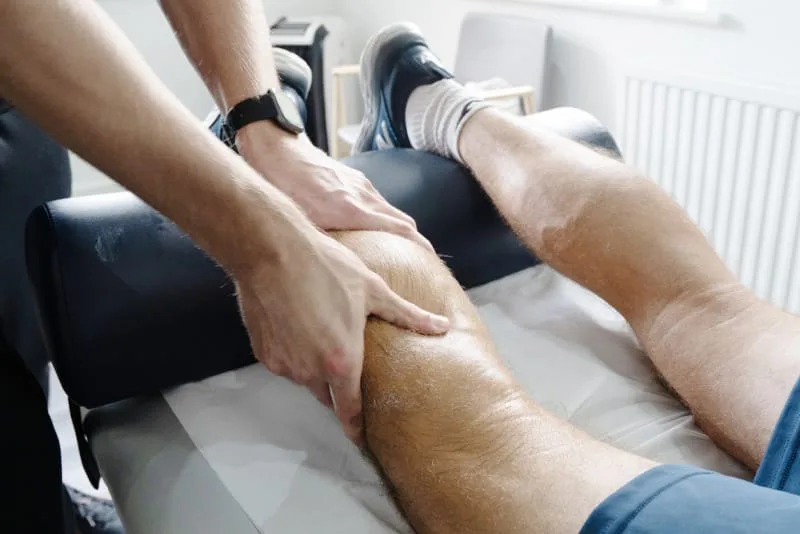 Therapist giving a sports massage to a calf